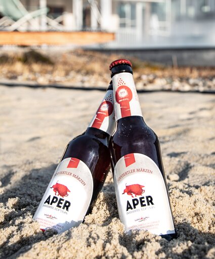 Zwei Flaschen Aper Bier stehen im Sand der Karibischen Saunawelt des Spa Resort Geinberg | © Spa Resort Geinberg