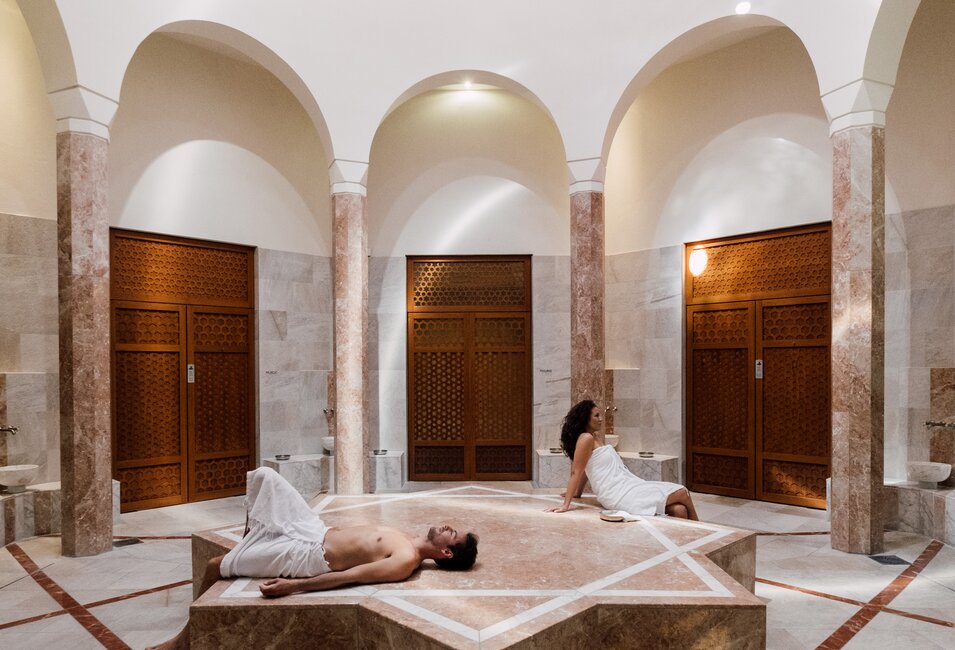 Paar genießt die Wärme des beheizten Nabelsteins in der Oriental World | © Spa Resort Geinberg / Chris Perkles