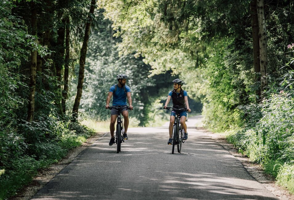 Sportliches Paar unternimmt eine gemeinsame Radtour im Grünen durch den Geinberger Wald | © Spa Resort Geinberg / Chris Perkles
