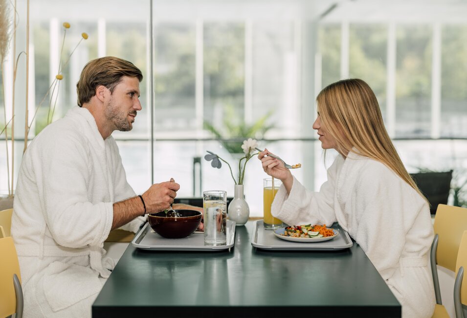 Paar im Bademantel genießt ein köstliches Mittagessen im Thermen-Restaurant des Spa Resort Geinberg  | © Spa Resort Geinberg / Chris Perkles