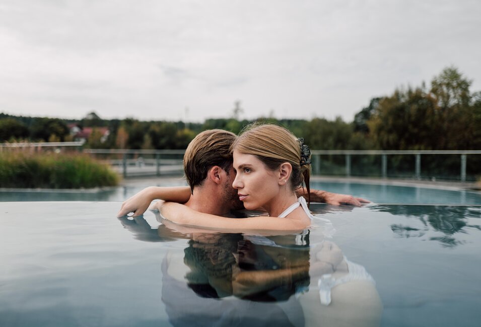 Paar entspannt bei Umarmung im Kaskaden-Becken im Spa Resort Geinberg  | © Spa Resort Geinberg / Chris Perkles